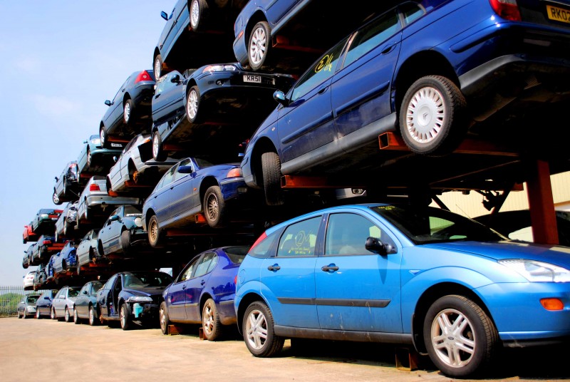 Salvaged cars stacked in racking for auction or breaking